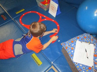 A boy is building a track with the layout in a figure 8