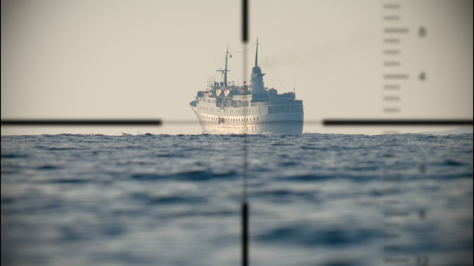 This is an image of a  boat as seen through the periscope of a submarine.  The periscope is using cross hairs to show  alignment of the boat on the horizon