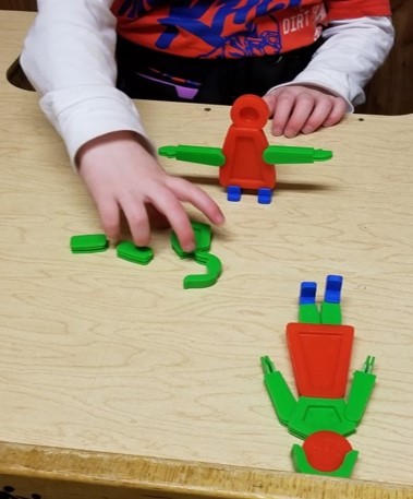 this photo shows a child who is using the Groovy People toy to build a matching figure of a person.