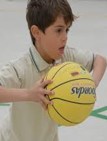 This is a photo of a boy who is holding a basketball with both hands 