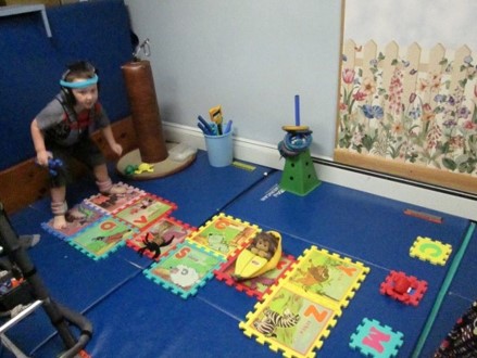 This picture shows a girl who is jumping on floor tiles that are laid out in a hop scotch pattern