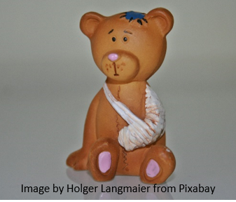 this photo shows a toy stuffed bear who has his arm in a sling