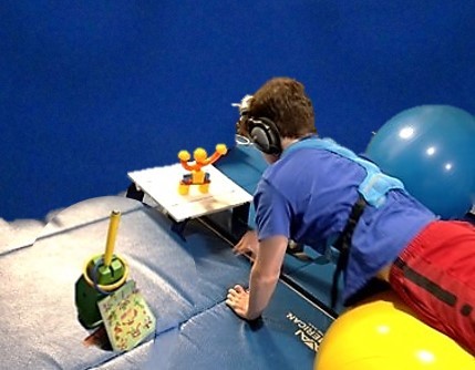 This photo shows an older boy walking out on a physioroll to collect and build a magnetic robot.