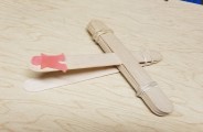 This photo shows a catapult that has been made using jumbo craft sticks and rubber bands.  A soft rubber figure has been placed on the trigger and is ready to be launched.