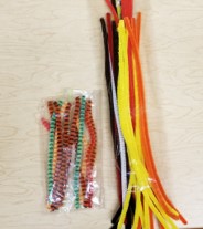 The photo shows two packs of pipe cleaners.  One pack with tall pipe cleaners is filled with traditional colors.  The pack that is filled with striped pipe cleaners holds shorter sticks.