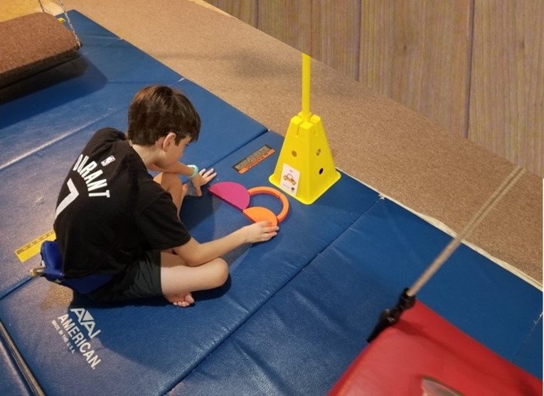 This photo shows a youngster who is using Tieramid blocks  to copy the model shown on a task card.  He will need to integrate his visual perceptual skills with spatial language in order to accomplish this task.