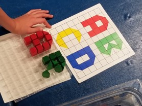The game “Peg Pen” offers activities that help children lean to link visual perceptual skills with language. The youngster in the photo above is learning to match simple shapes and colors of the pegs to build each upper-case letter within the frame of the pegboard